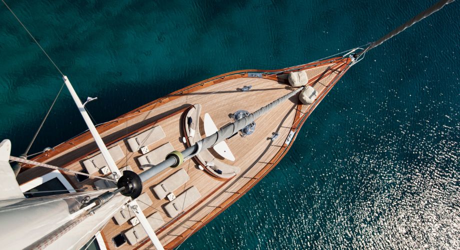 A picture of a yacht deck made of wood. Learn about yacht decks, teak wood decking, prefabricated decks, and tips for maintaining luxury yacht deck surfaces.
