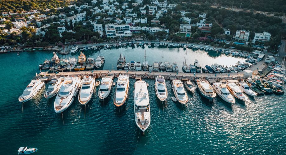 Yacht Ownership | YATCO A bunch of luxury yachts docked in the ocean.